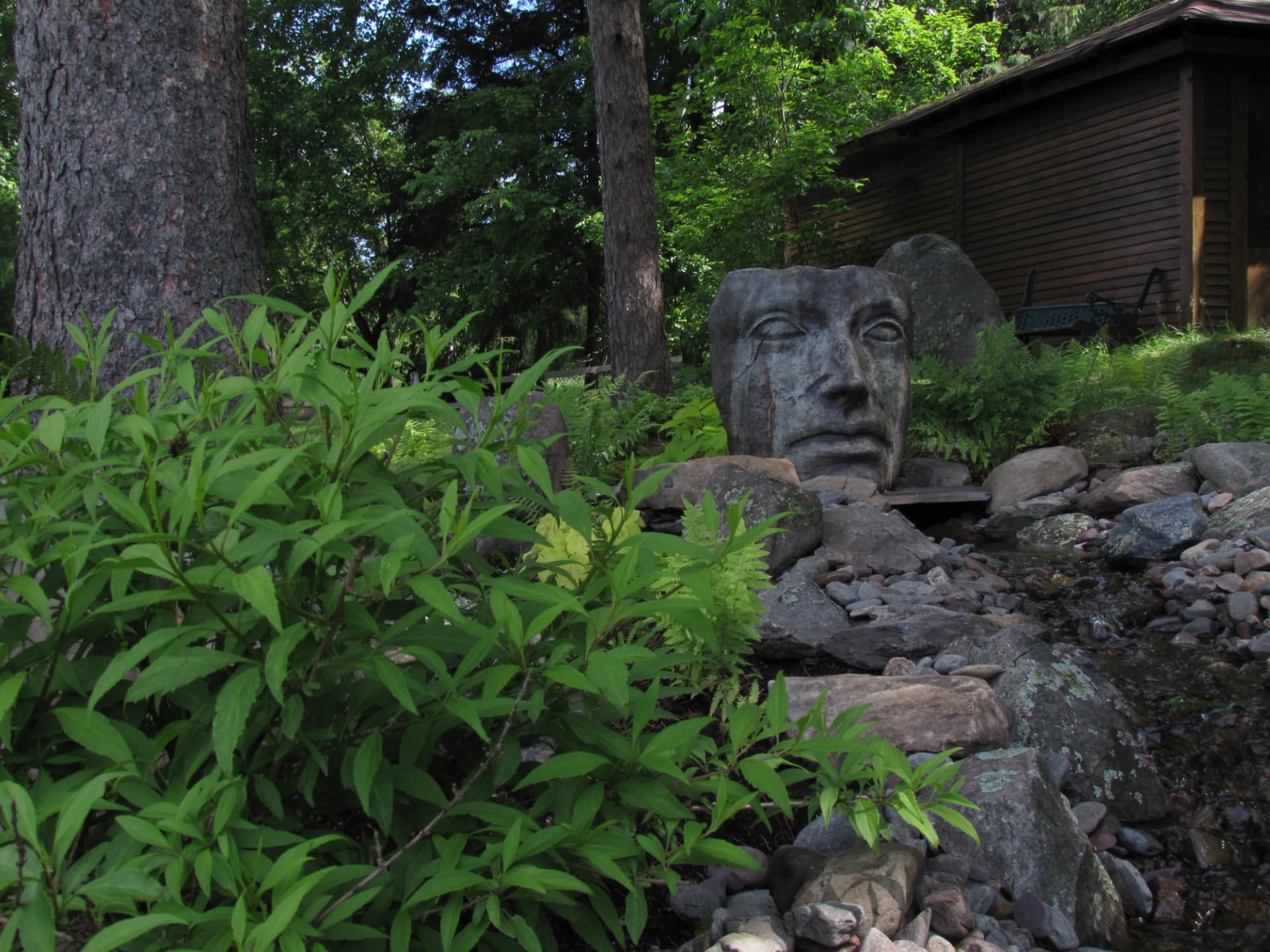 Visage de pierre au bord du ruisseau